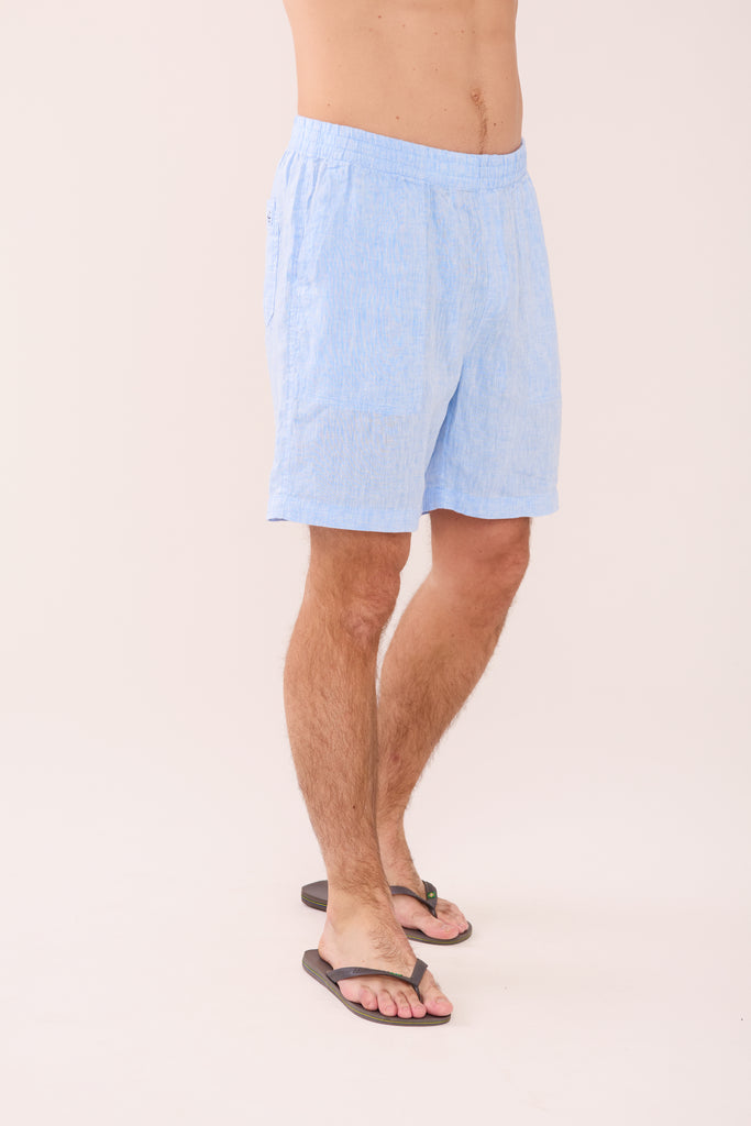 Person wearing light blue shorts on a plain background