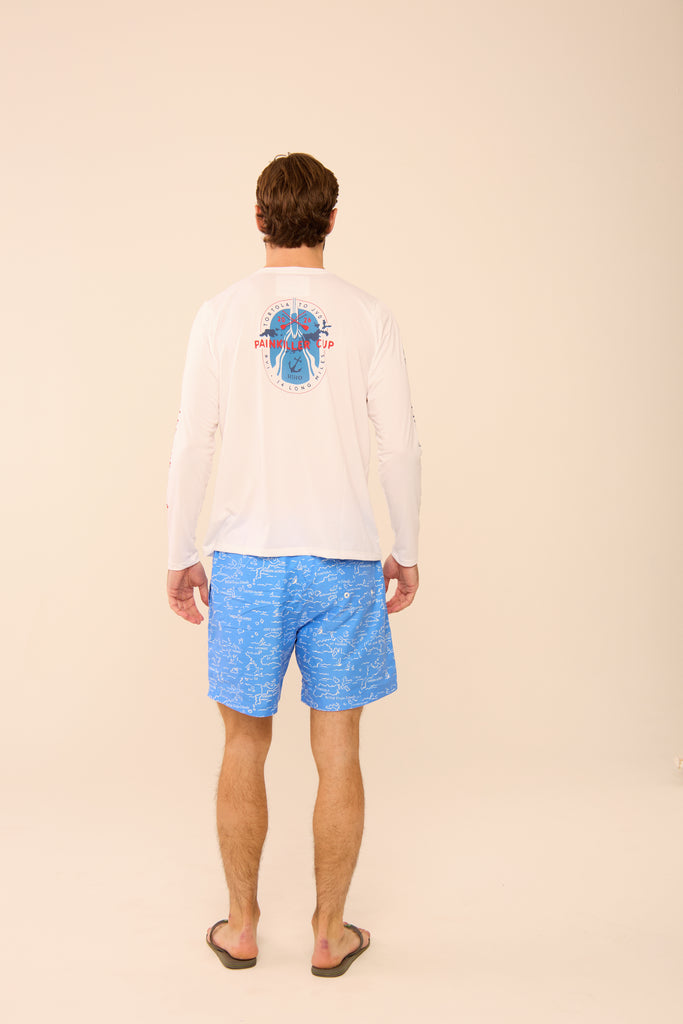 Man wearing a white long-sleeve shirt with a graphic on the back and blue patterned shorts, standing against a beige background.