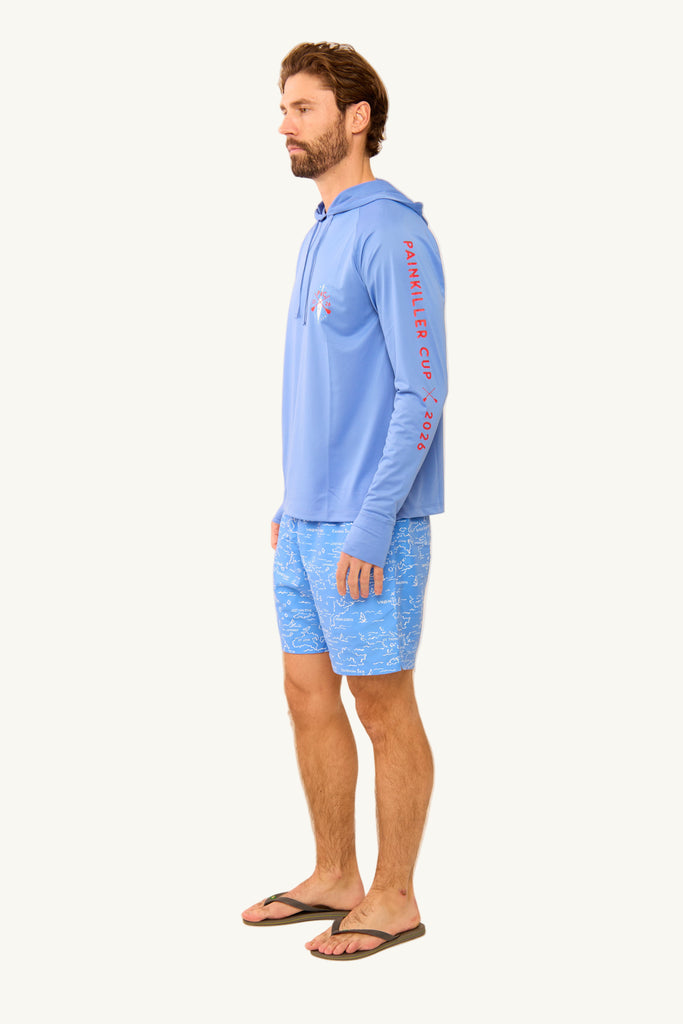 Man wearing a light blue long-sleeve shirt and patterned shorts on a beige background